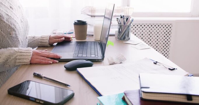 Online learning. Home study. Unrecognizable woman professional working at desk typing notes at workplace with laptop smartphone indoor.