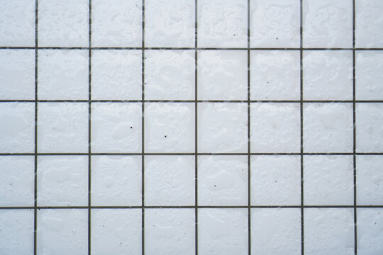 White textured square tiles with gray grout lines forming a clean geometric pattern ideal for design projects, backgrounds, or minimalist aesthetic compositions, elegantly showcasing wall.