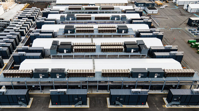 Aerial view of a large data center facility with rows of modular server units, cooling systems, and industrial infrastructure in Keflavik, Reykjanesbaer, Iceland.