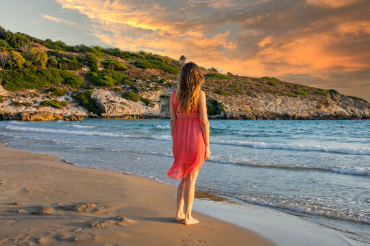 Symphony of crimson and gold where her dress lights up the sunset on the sea