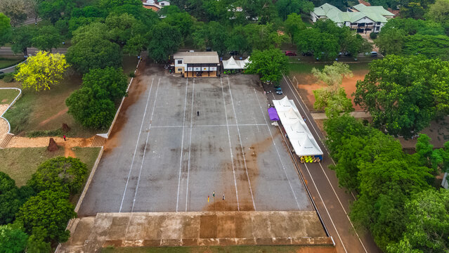 Aerial view of the parade square at Achimota School surrounded by lush green trees and campus buildings in Achimota, Greater Accra Region, Ghana.