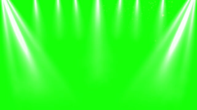 Spotlights illuminate a stage from above against a bright green screen background for chroma key compositing.