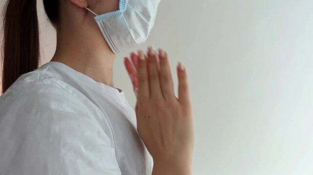 Woman putting on a surgical face mask for protection against viruses and diseases, a crucial personal protective equipment measure for public health and safety