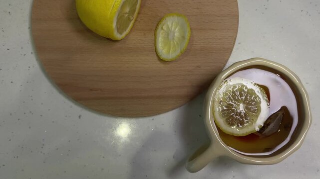 Preparing healthy herbal tea with lemon and honey on a white kitchen counter, a top down view showing a warm and comforting beverage perfect for a relaxing moment