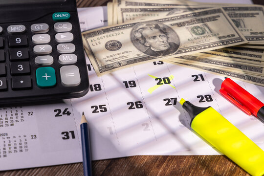 Calendar page with highlighted tax payment date near corporate calculator and red markers on workspace desktop background.