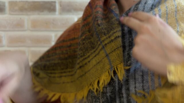 Woman with fever measuring her body temperature using a classic mercury thermometer, wrapping herself in a warm plaid scarf to combat chills and shivering from influenza