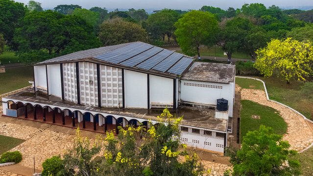 Aerial view of Achimota School featuring a modern building with solar panels on the roof, surrounded by lush green trees and stone pathways in Achimota, Greater Accra Region, Ghana.