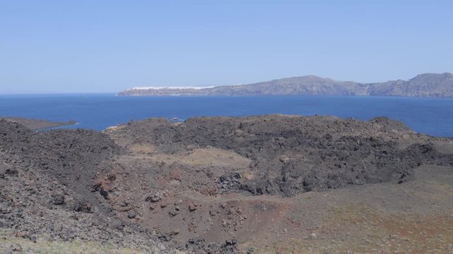 Nea Kameni volcano black rocks and volcanic landscape in Santorini, showcasing the raw volcanic terrain formed by ancient eruptions.