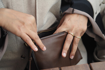 Hands reaching into a brown bag in a cafe