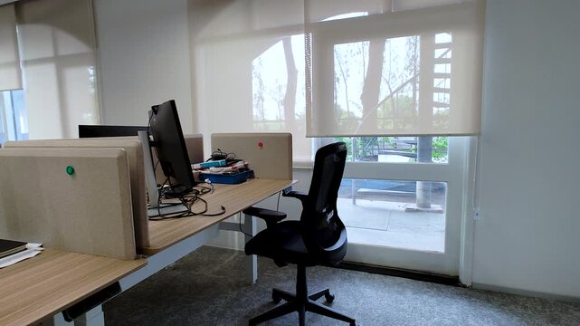 Modern corporate office workspace with computer desk, ergonomic chair and natural daylight. Ideal for business, hybrid work, office culture, productivity and workplace concepts.