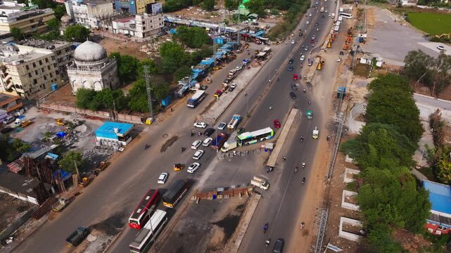 Patancheruvu Highway Intersection Traffic flow with Dargha Hazrat Syed Nizamuddin Shaheed and Graveyard at Patancheru, hyderabad, telangana, india. day time, stable shot, drone shot, 4k.