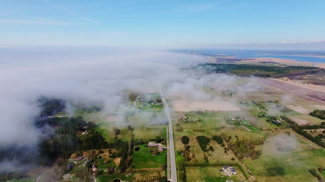 Drone slightly descends above the A11 highway near Bernati facing toward Liepaja