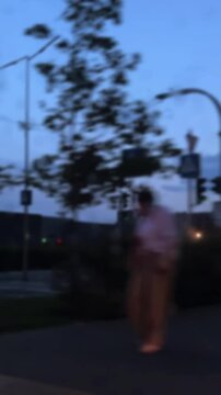 Blurry view from moving vehicle window showing abstract city street scene at dusk with traffic lights, cars, and blurred people creating a cinematic urban mood