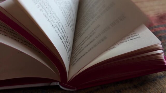 Close up of book pages turning rapidly, representing fast reading, storytelling, and the constant flow of information while studying or searching for knowledge