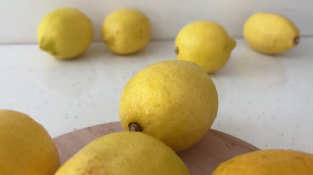 Fresh ripe organic lemons dolly out on a kitchen countertop for healthy eating and vitamin c, close up of yellow citrus fruits for making refreshing lemonade
