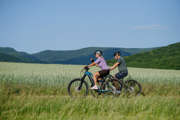 Fototapeta premium Active senior couple exploring nature on electric bicycles