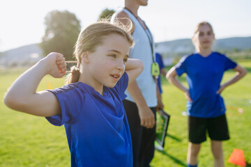 Naklejka premium Children helping prepare football training session on sports field.