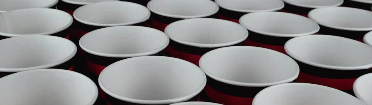 Empty disposable paper cups arranged in neat rows forming a striking repeating pattern Ready for beverages or party games.