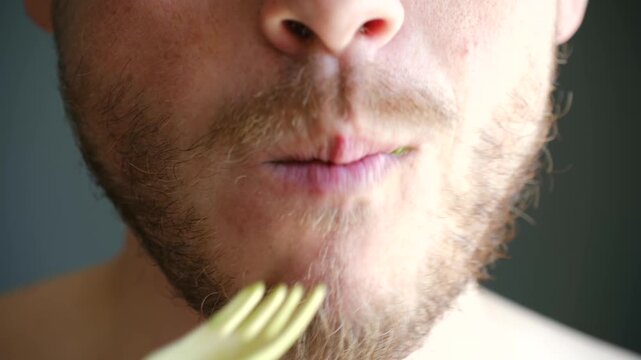 Extreme close up bearded man mouth eating fresh green salad with fork. Healthy lifestyle concept, focusing on nutritious food, vegetarian diet, and proper eating habits for wellness. Vertical video.