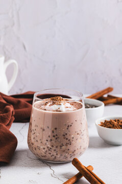 Overnight oats with chia seeds and cinnamon in a glass on the table vertical view