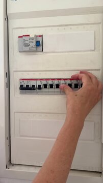 electrician checking main fuse box and circuit breakers during home inspection