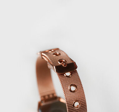 Macro Detail of Rose Gold Mesh Watch Strap and Adjustable Clasp on Clean White Background