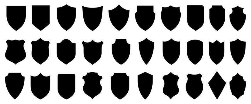 Large collection of black shield silhouettes in various classic, medieval, and modern shapes, presented as a set of graphic icons for emblems and logos