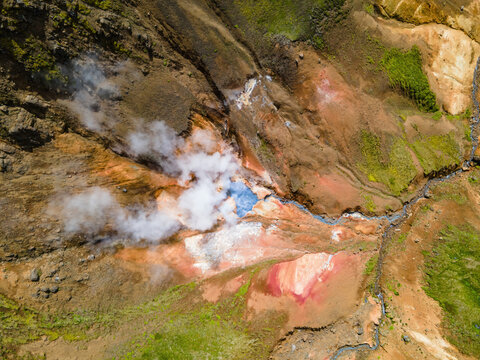Aerial view of the geothermal area in Grensdalur, featuring steam vents, vibrant mineral deposits, and rugged volcanic terrain in Sveitarfelagid Olfus, Iceland.