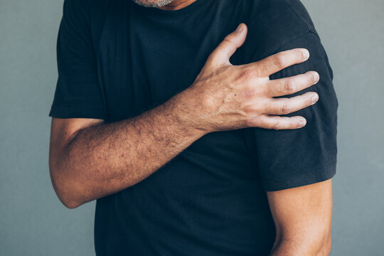 Closeup of male hand grasping shoulder in pain
