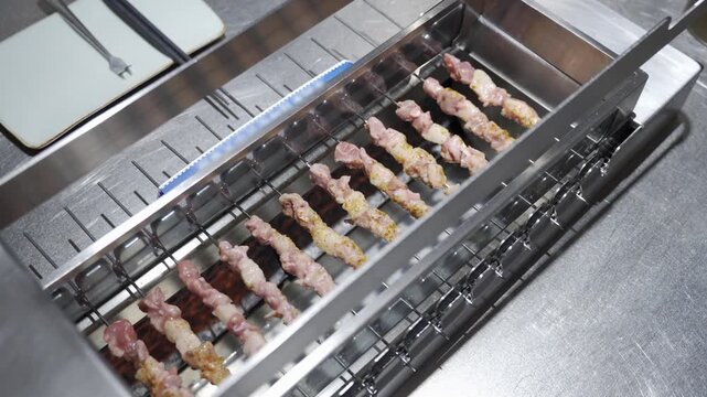 close up view to self grilled meat skewer in chinese style food smokey charcoal flame grill skew chicken, beef, mutton meet kebab.self grilled mutton skew machine