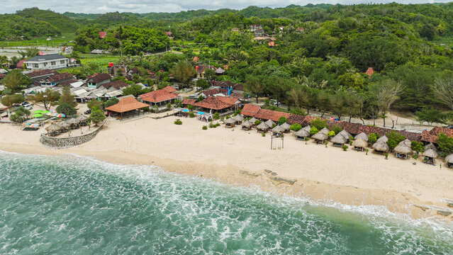 Aerial view of a beautiful tropical sandy beach and lush green hills 