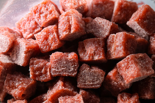 Frozen beef chunks for dog food close up, showing texture and frost on meat pieces, perfect for pet nutrition and feeding