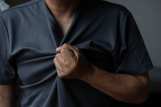  胸を押さえる男性の上半身