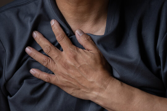  胸を押さえる男性の上半身