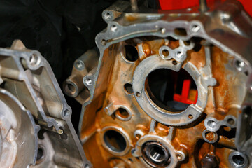 Fototapeta premium Rusty engine part close up with metal casing showing mechanical details and circular openings in workshop environment