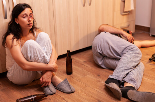 Abused woman traumatized by alcoholic partner inside a tense home situation with emotional distress, alcohol problems and relationship conflict clearly shaping the moment.