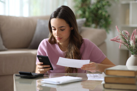 Serious woman checking phone doing online accounting herself