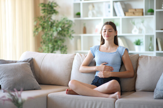 Teen at home enjoying healthy bowel tract touching belly