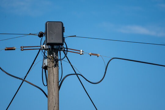 Telecommunications distribution box and overhead cables on a wooden utility pole