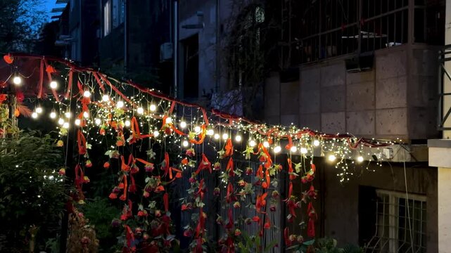 red ribbon of string lights of decorative cafe restaurant in outdoor nightlife evening of urban cityscape in Yerevan Armenia ambiance glowing warm festive romantic terrace travel tourism winter season