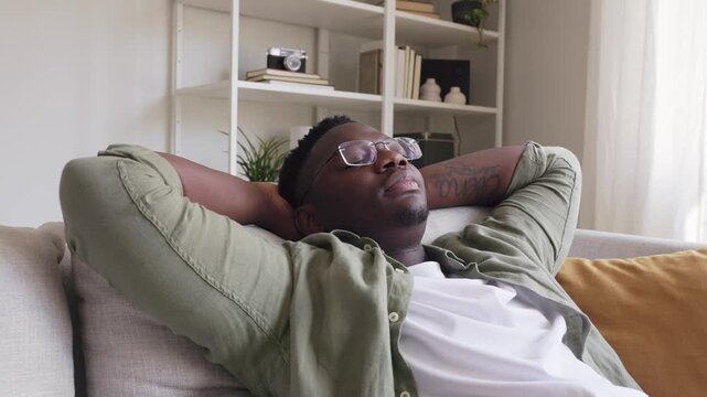 Relaxed african american man resting on couch at home