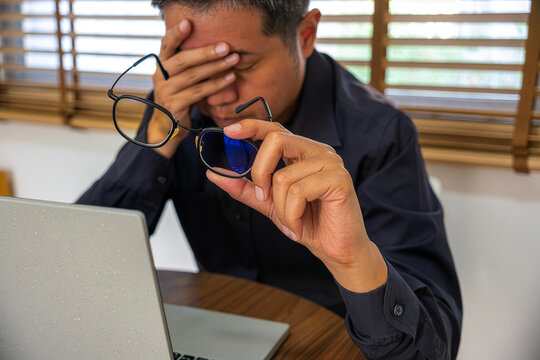 Headache from vision problems, stressed worker at laptop, eyeglasses treatment and ophthalmology support concept.