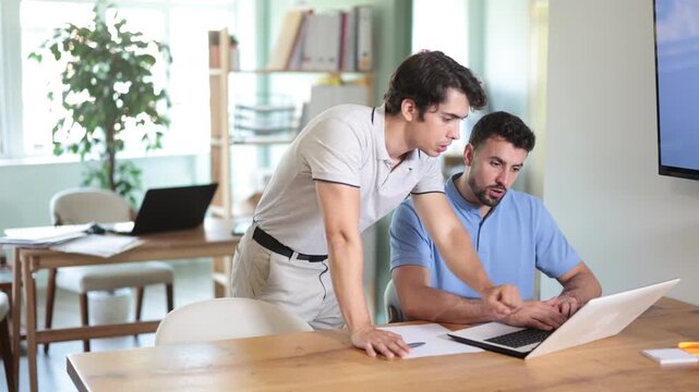 Man helping male colleague in work in modern coworking space . High quality 4k footage