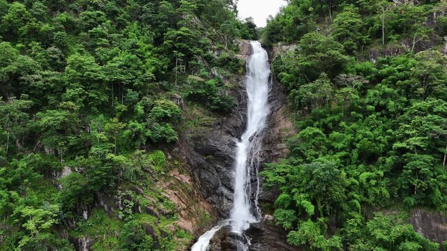 Aerial video of a massive waterfall in the forest.