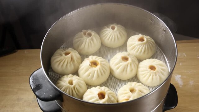 Slow motion close up of steaming hot freshly cooked Chinese baozi buns in a metal steamer pot.