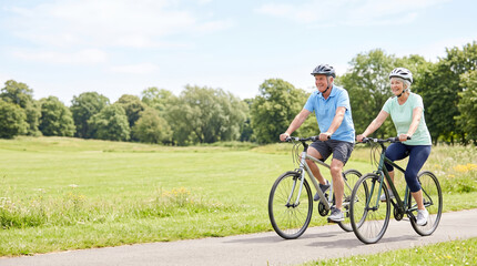 Fototapeta premium Active couple enjoying a bike ride together outdoors