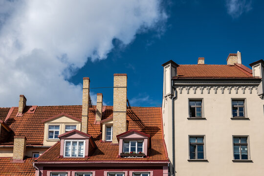 Historic European Buildings With Red Tile Roofs Under a Blue Sky