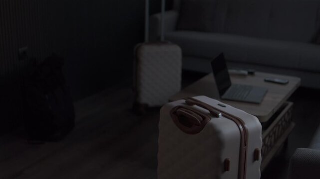 Remote worker relocation setup with luggage and laptop in rental apartment, copy space background for travel, expat and digital nomad concepts