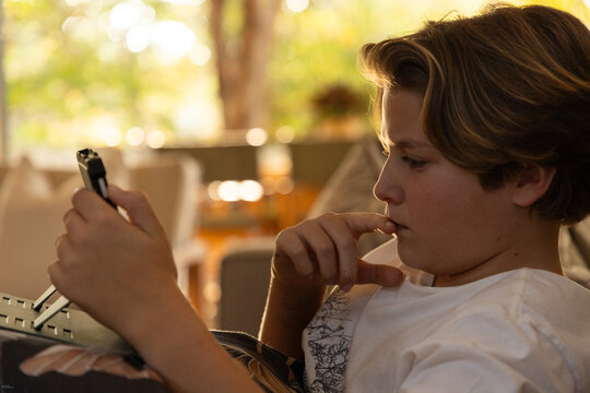close up profile of pre teen boy looking at tablet computer at home