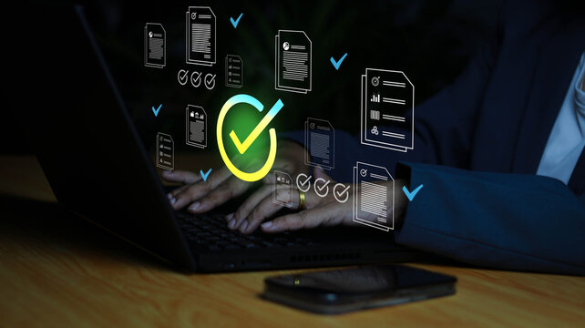 Business professional reviewing digital documents with online approval checklist and verified workflow on laptop. Concept of document management, compliance, audit, validation, quality control 